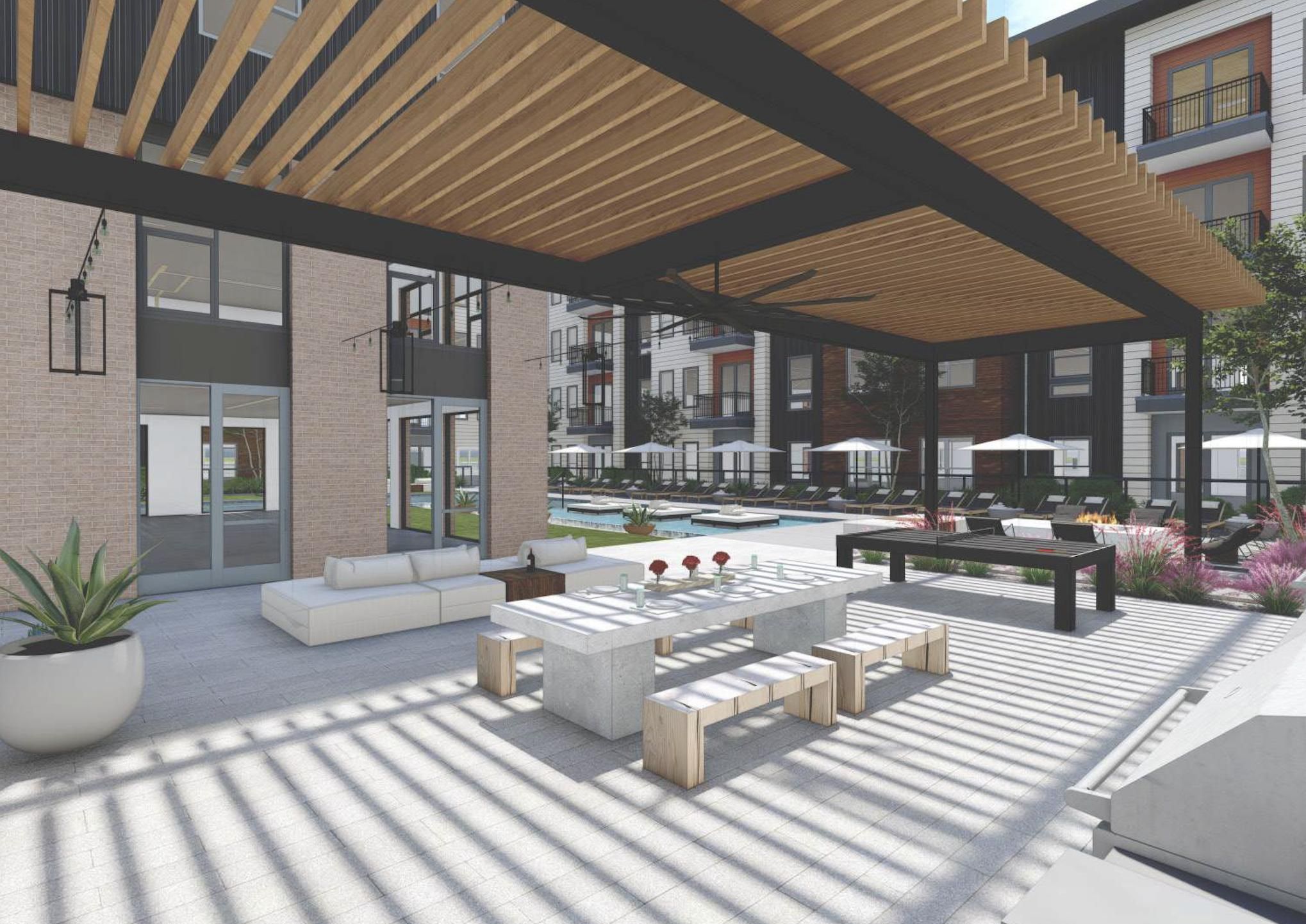 Modern outdoor patio with wooden pergola, dining table, lounge seating, and view of apartment complex and pool.